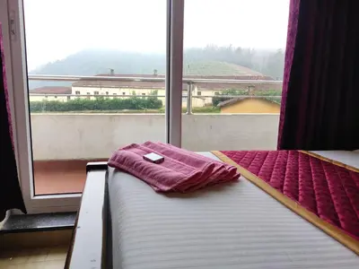 a bed with a towel on it in front of a window at Forest Gate villa in Ooty