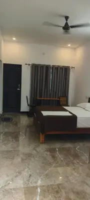 a bedroom with a large bed and a window at Dream Nest Resort in Mettuppālaiyam