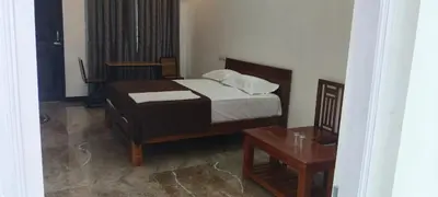 a small bedroom with a bed and a table at Dream Nest Resort in Mettuppālaiyam