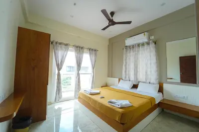 a bedroom with a bed and a large window at Nandan Enclave in Mysore