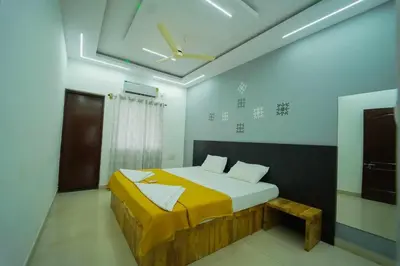 a bedroom with a bed with a yellow blanket on it at Nandan Enclave in Mysore