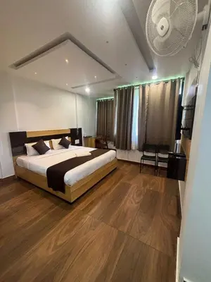 a bedroom with a large bed and a fan at Lush Hills by Benchmark in Kalpetta