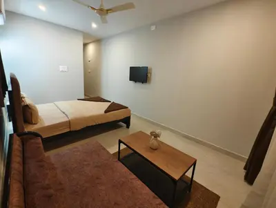 a bedroom with a bed and a tv on the wall at Aadvik Luxury Farmstay in Antarasante