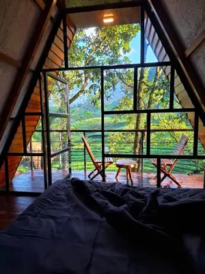 a room with a bed and a table and chairs at Forestscape Resort Munnar in Munnar