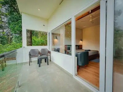 a room with a balcony with a bedroom and a bed at Forestscape Resort Munnar in Munnar