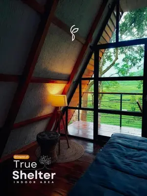 a room with a bed and a lamp and a window at Forestscape Resort Munnar in Munnar