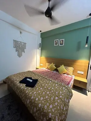 a bedroom with a large bed with a green wall at 1 BHK Fully Furnished - Soorya Madhavam Apartments - Flat No - C2 - Guruvayur, - 150m to North Nada - Family only in Guruvāyūr