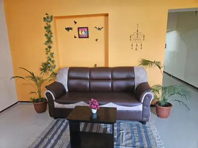 a living room with a leather couch and a table at SHI's Ganga 2BHK in GN Mills, Ganga Hospital, Women's Care Coimbatore in Coimbatore