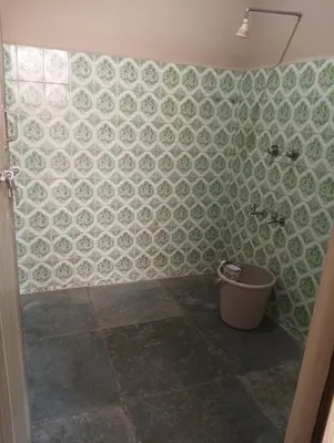 a bathroom with a green and white tiled wall at SHI's Ganga 2BHK in GN Mills, Ganga Hospital, Women's Care Coimbatore in Coimbatore