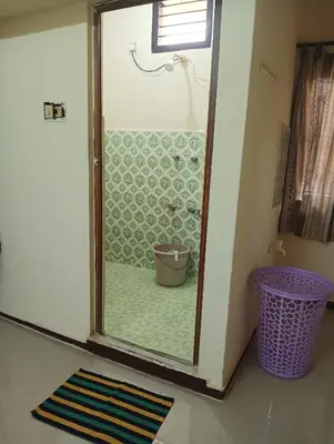 a bathroom with a shower with a glass door at SHI's Ganga 2BHK in GN Mills, Ganga Hospital, Women's Care Coimbatore in Coimbatore