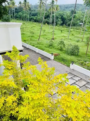 a view of a garden with yellow flowers at Haven Stay Manor in Kotamangalam