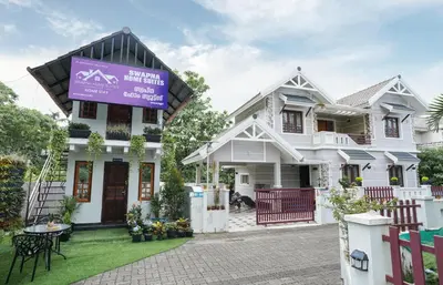 a house with a sign in front of it at Swapna Home Suites in Nedumbassery