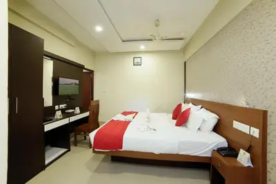 a bedroom with a bed and a desk with a computer at Sreepathi Indraprastha in Guruvāyūr