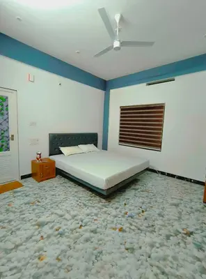 a bedroom with a bed and a ceiling fan at Dream Nest Villa Wayanad in Kalpetta