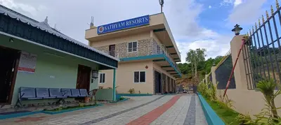 a building with a sign on top of it at Sathyam Resorts in Dharmapuri