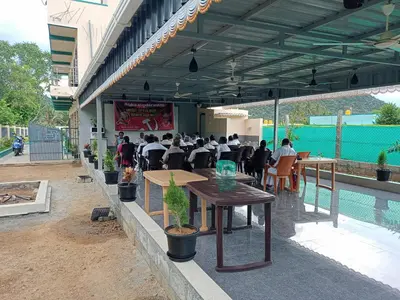 a group of people sitting at tables in a restaurant at Sathyam Resorts in Dharmapuri