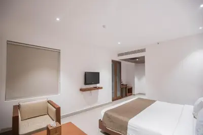 a bedroom with a bed and a flat screen tv at Hotel Niya Regency in Trichūr