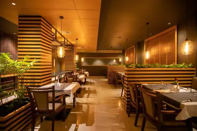 a restaurant with tables and chairs in a room at Hotel Niya Regency in Trichūr