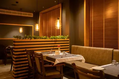 a dining room with a table and chairs and lights at Hotel Niya Regency in Trichūr