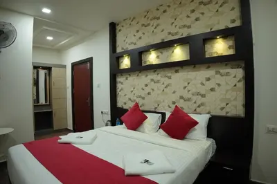 a bedroom with a large bed with red pillows at Hill Club Square in Malappuram