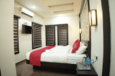 a bedroom with a bed with white and red pillows at Hill Club Square in Malappuram