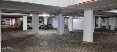 an empty parking garage with a motorcycle parked in it at VVP Service Apartments & Airport Suits in Cochin