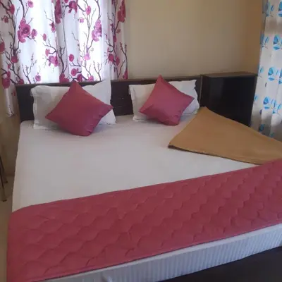 a bed with red and white pillows on it at RIVERVIEW HOMESTAy in Vālpārai