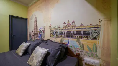 a bedroom with a mural on the wall at Trippr Mysuru in Mysore