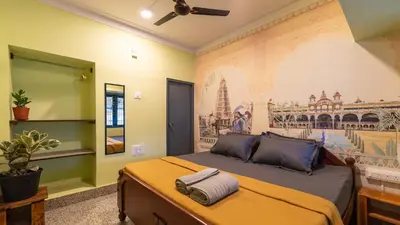 a bedroom with a bed with a painting on the wall at Trippr Mysuru in Mysore