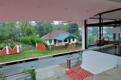 a view of a house from the window of a building at Josebaa Inn in Vythiri