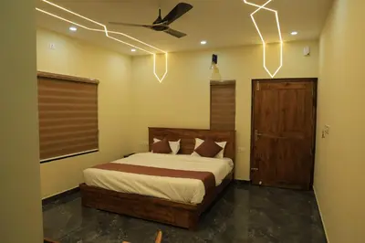 a bedroom with a bed and a ceiling fan at Josebaa Inn in Vythiri