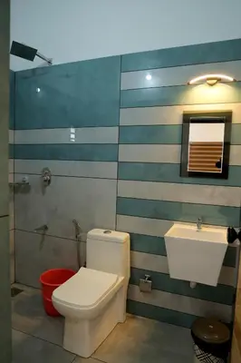 a bathroom with a toilet and a sink at Josebaa Inn in Vythiri