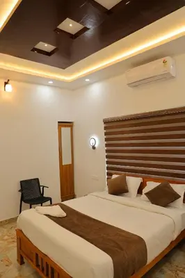 a bedroom with a large bed with a wooden headboard at Josebaa Inn in Vythiri