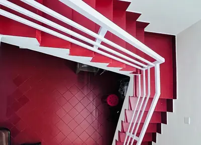 a spiral staircase in a room with a red wall at Churuli Bungalow in Ambalavayal
