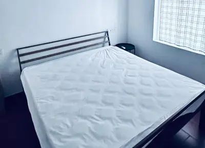 a large white bed in a bedroom with a window at Churuli Bungalow in Ambalavayal