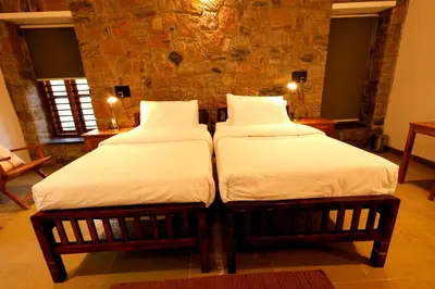 two beds sitting next to each other in a room at The Hidden Pearl Palakkad by Chakolas Hospitality in Thenkurissi