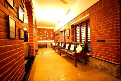 a row of benches in a room with a brick wall at The Hidden Pearl Palakkad by Chakolas Hospitality in Thenkurissi