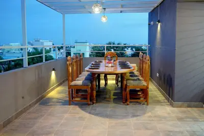 a table and chairs on a balcony with a view at Elite Enclave - Mysore - 2BHK Luxury Serviced Apartments in Mysore