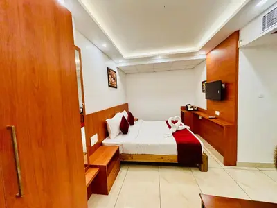 a small room with a bed and a tv at Hotel Starfinch Inn in Kushālnagar