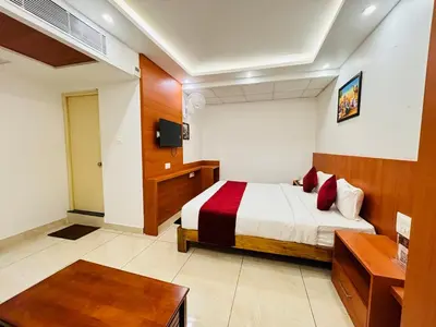 a hotel room with a bed and a television at Hotel Starfinch Inn in Kushālnagar