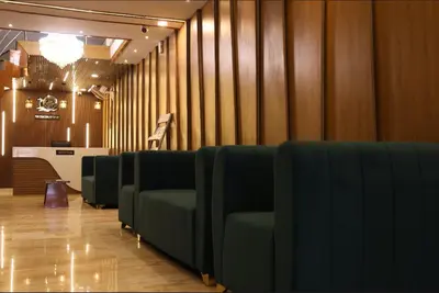 a row of green chairs in a waiting room at Hotel president park Coimbatore in Coimbatore