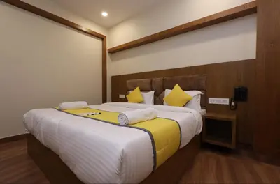 a bedroom with a large bed with yellow pillows at Hotel president park Coimbatore in Coimbatore