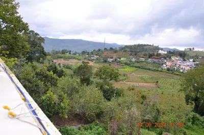 a view of a town on a hill with trees at Siesta Inn- Mountain View in Kodaikānāl