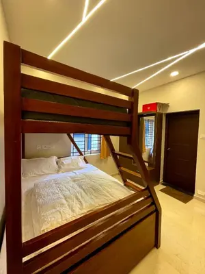 a bedroom with a wooden bed in a room at Siesta Inn- Mountain View in Kodaikānāl