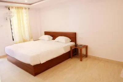 a bedroom with a large bed with a night stand at Palatty Residency in Angamali