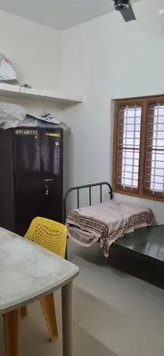 a room with two bunk beds and a table and chairs at Agraharam Hindu Home stay - Advaitham in Palakkad