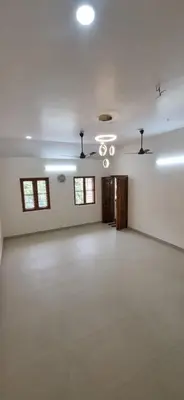 a large room with white walls and a chandelier at Agraharam Hindu Home stay - Advaitham in Palakkad