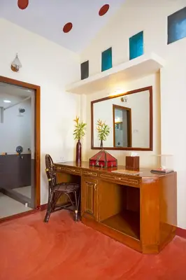 a desk with a mirror and a chair in a room at Kairali - The Ayurvedic Healing Village in Palakkad