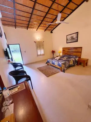 a bedroom with a bed and a chair in it at The Road's End in Gonikoppal