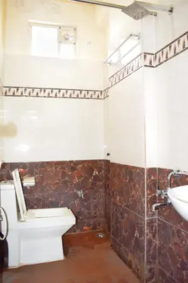a bathroom with a toilet and a sink at SAK Royal Residency 1 km from Railway Station in Mysore